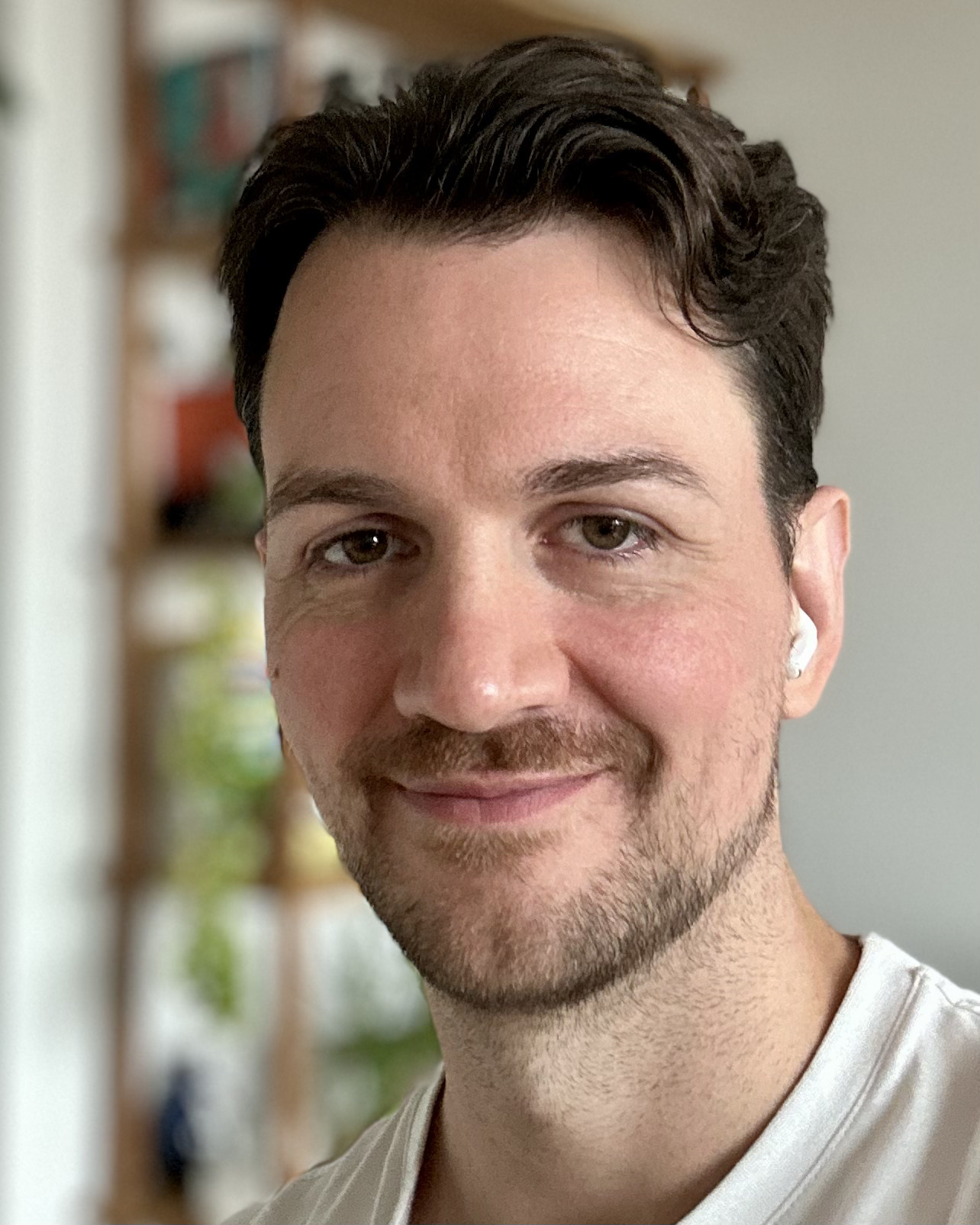 Portrait of a man smiling, dark hair, brown eyes, light skin and short beard